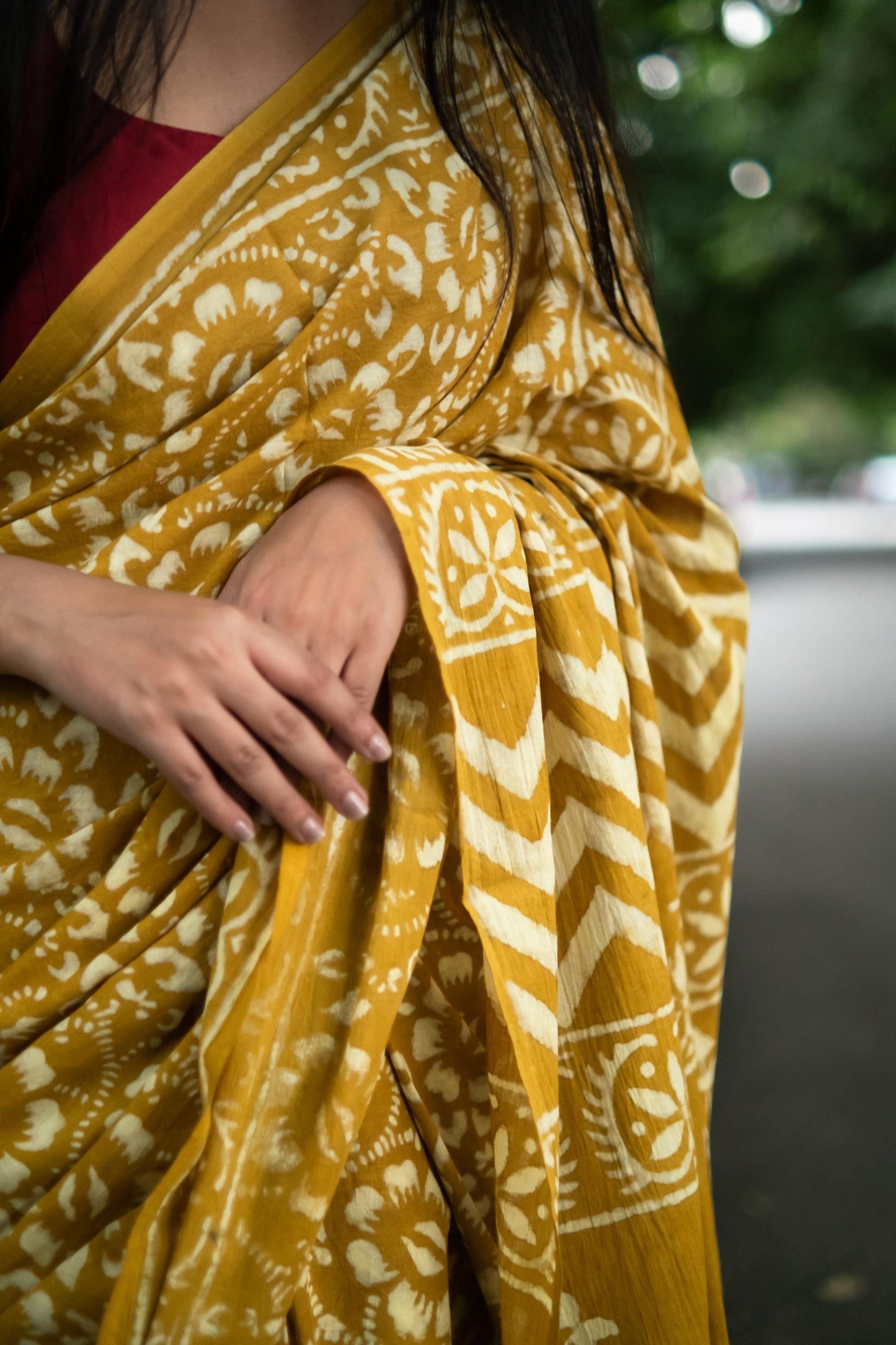 Yellow and white patterned fabric draped over a person with a blurred background